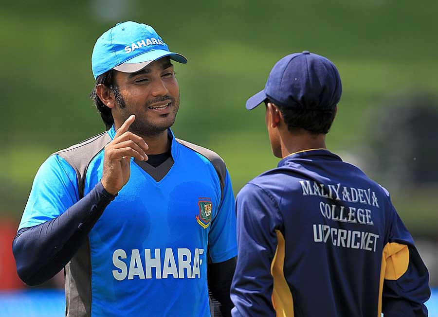 Junaid Siddique speaks to a budding cricketer at a cricket clinic in Pallekele