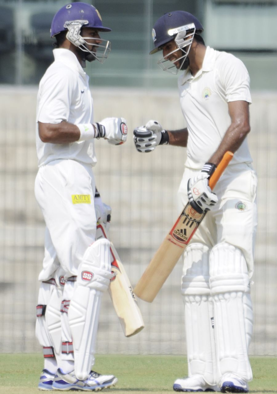 Shikhar Dhawan and Rahul Dewan celebrate as their partnership reached the 100-run mark