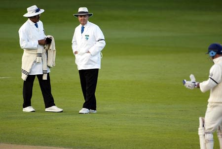 Umpires Venkataraghavan and Cowie offer the light to the England batsmen