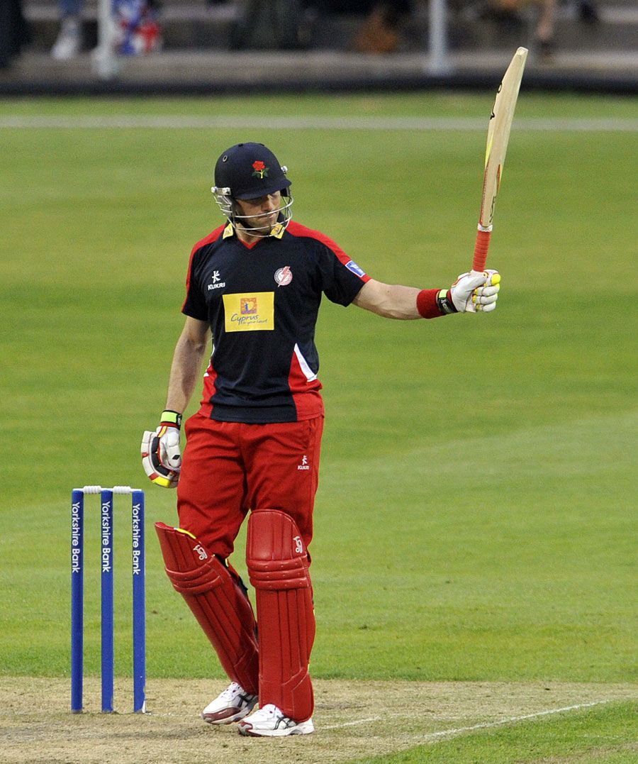 Stephen Moore raises his bat after reaching fifty