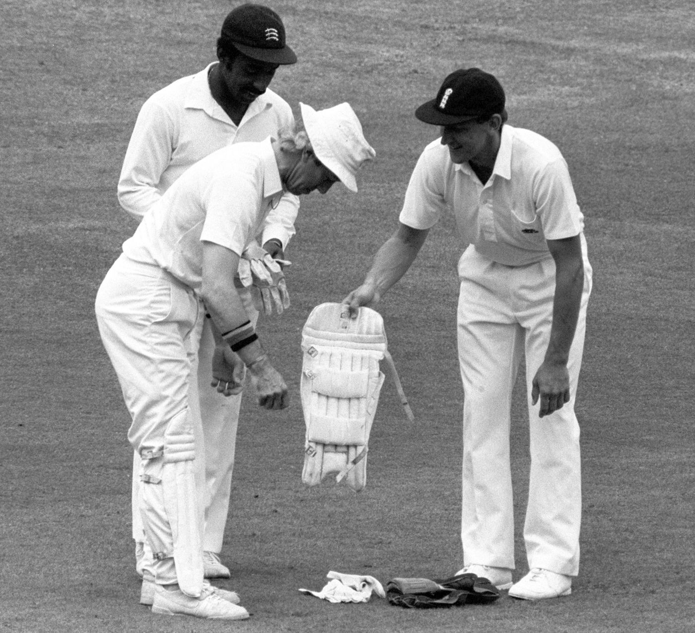 Bill Athey helps substitute keeper Bob Taylor put his pads on while Roland Butcher holds the gloves