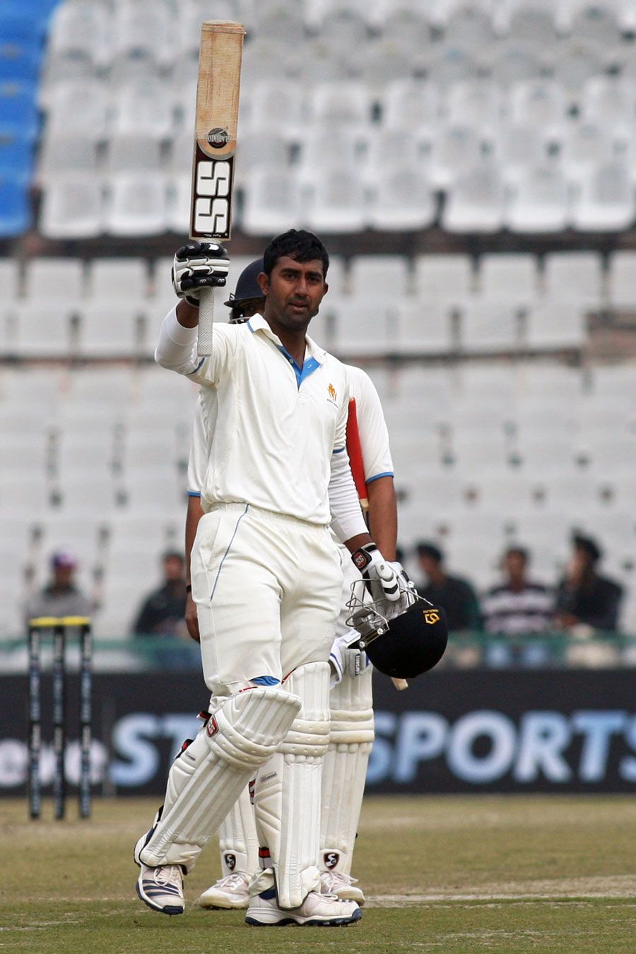 Amit Verma raises his bat after scoring a century