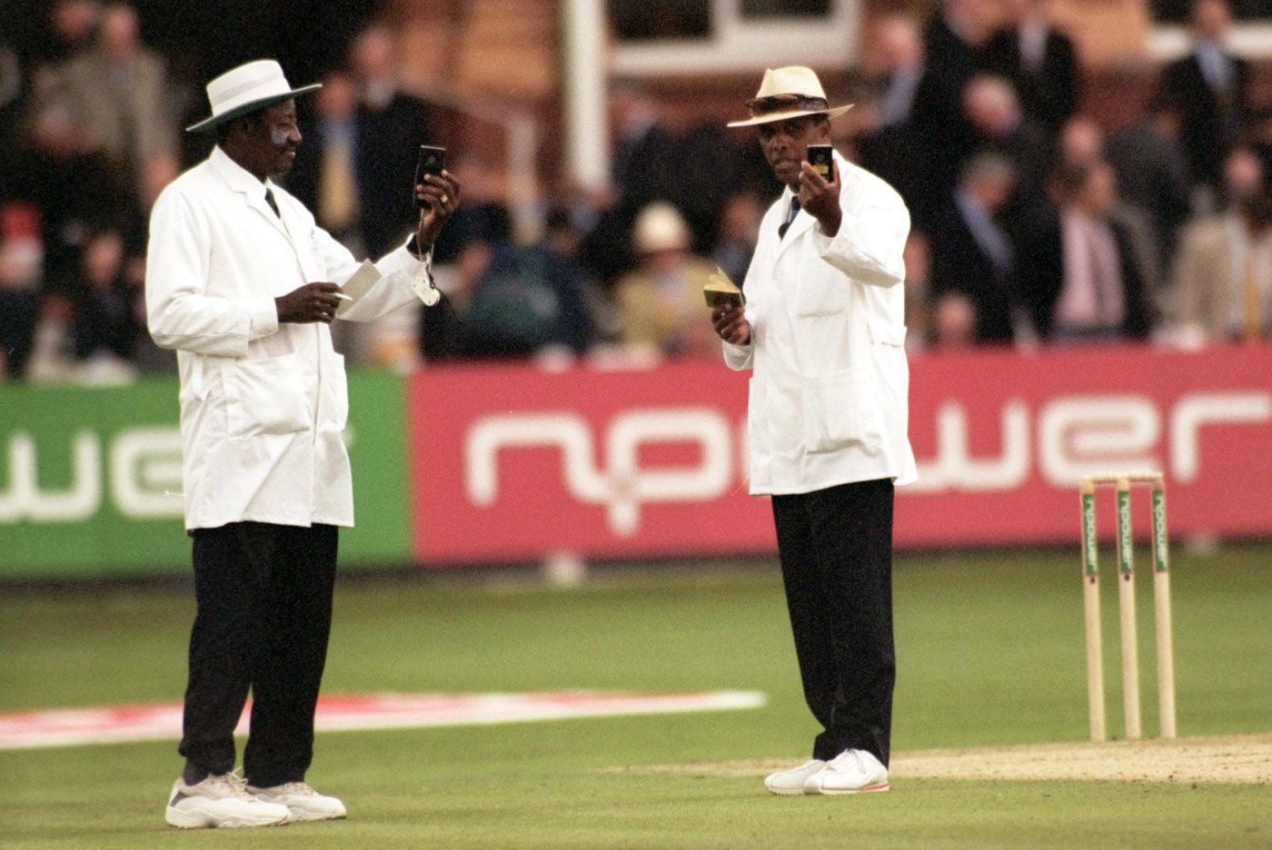 Umpires Steve Bucknor and John Holder check the light