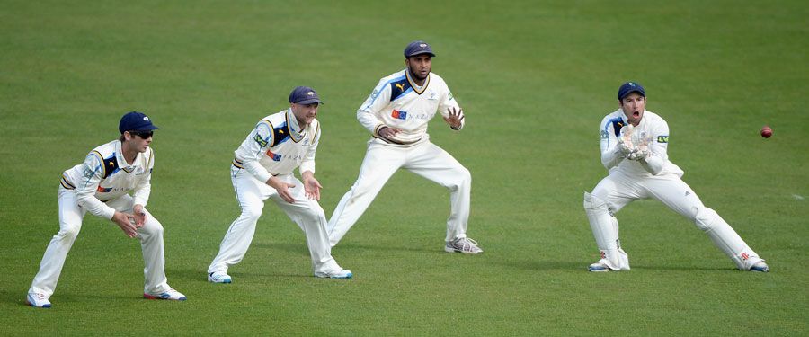 Andy Hodd takes a catch as the slip cordon looks on