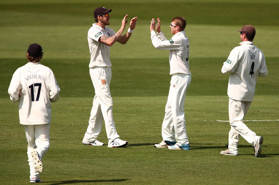 Ben Harmison and Adam Riley high five after combining for a wicket