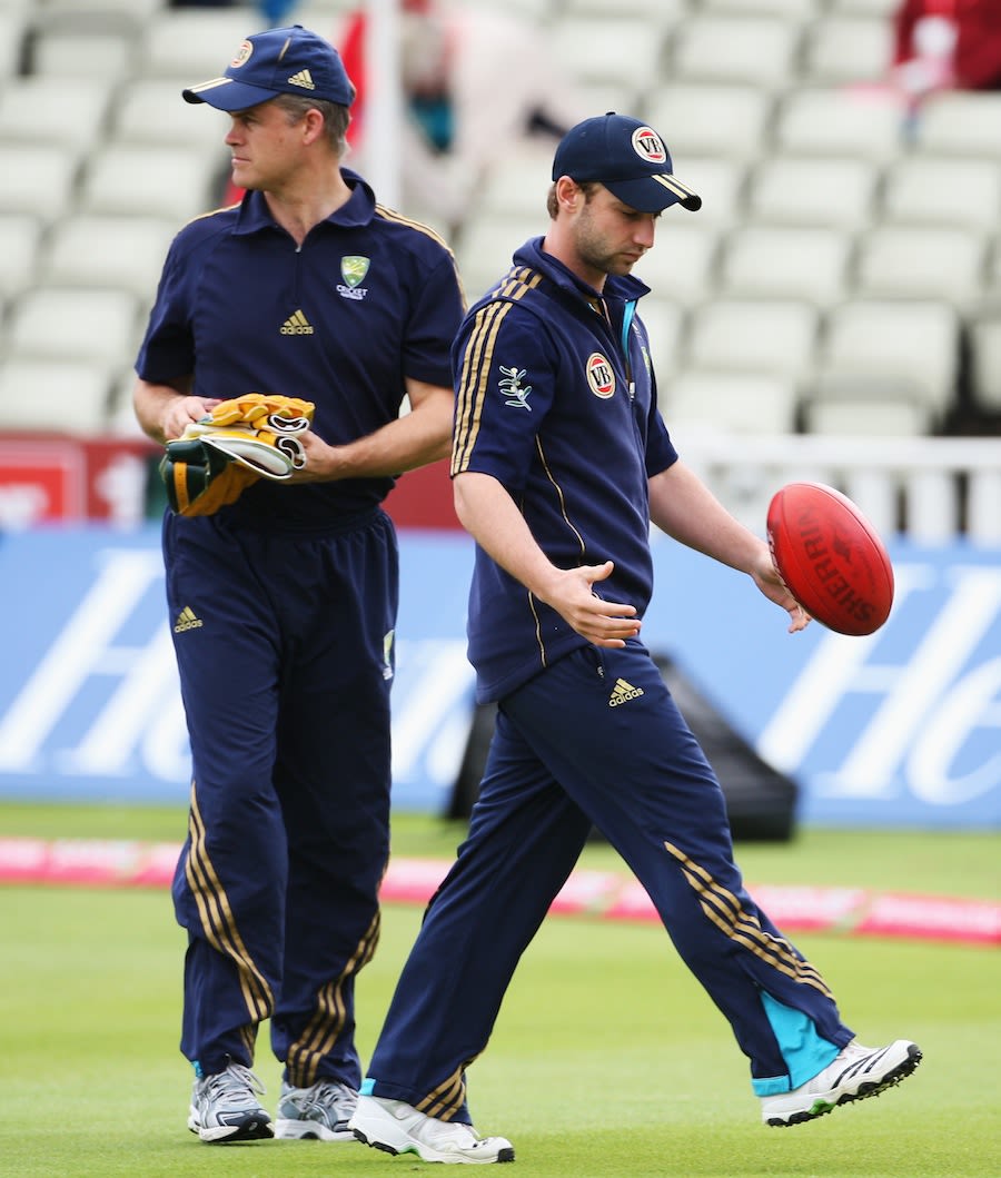 Phillip Hughes walks past Jamie Cox