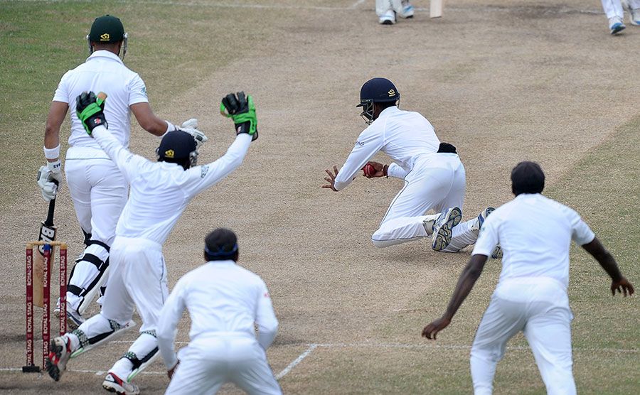 Kithuruwan Vithanage tumbles to his right to catch Alviro Petersen at silly point