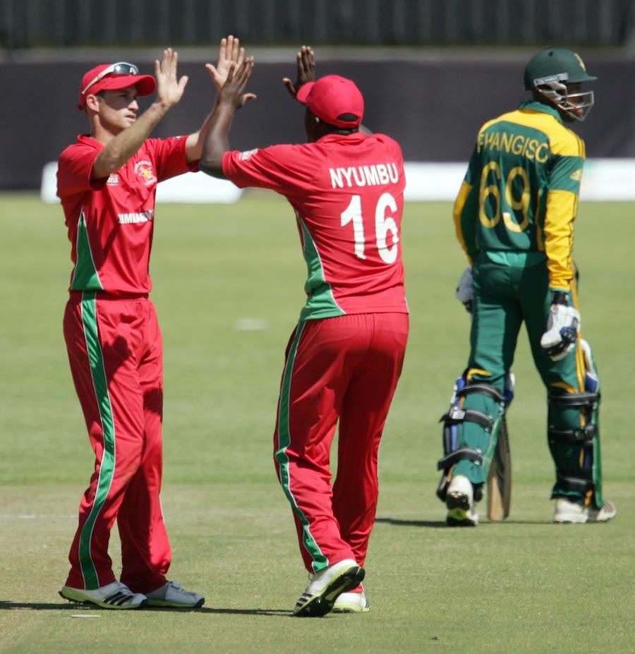 Sean Williams and John Nyumbu celebrate the dismissal of Aaron Phangiso