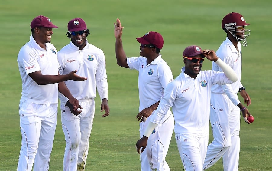 West Indies players celebrate the fall of a wicket