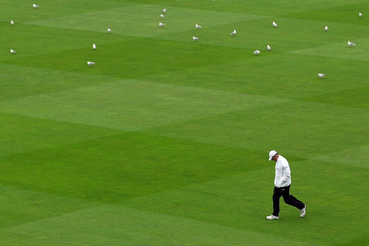 Umpire Tony Hill walks back after inspecting the pitch
