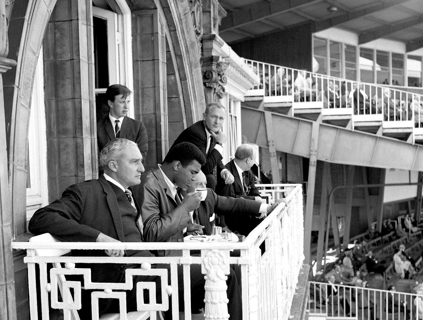 Muhammad Ali sips a cup of tea on the Lord's balcony next to West Indies manager Jeffrey Stollymeyer