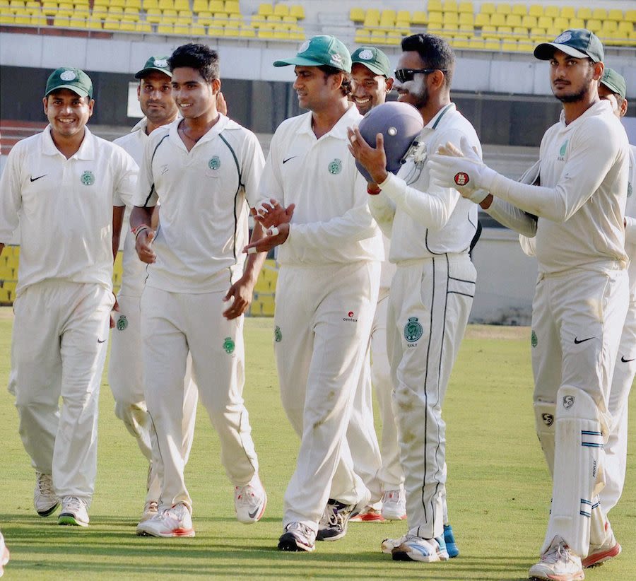 Arup Das (second from left) is cheered by his team-mates for taking four wickets