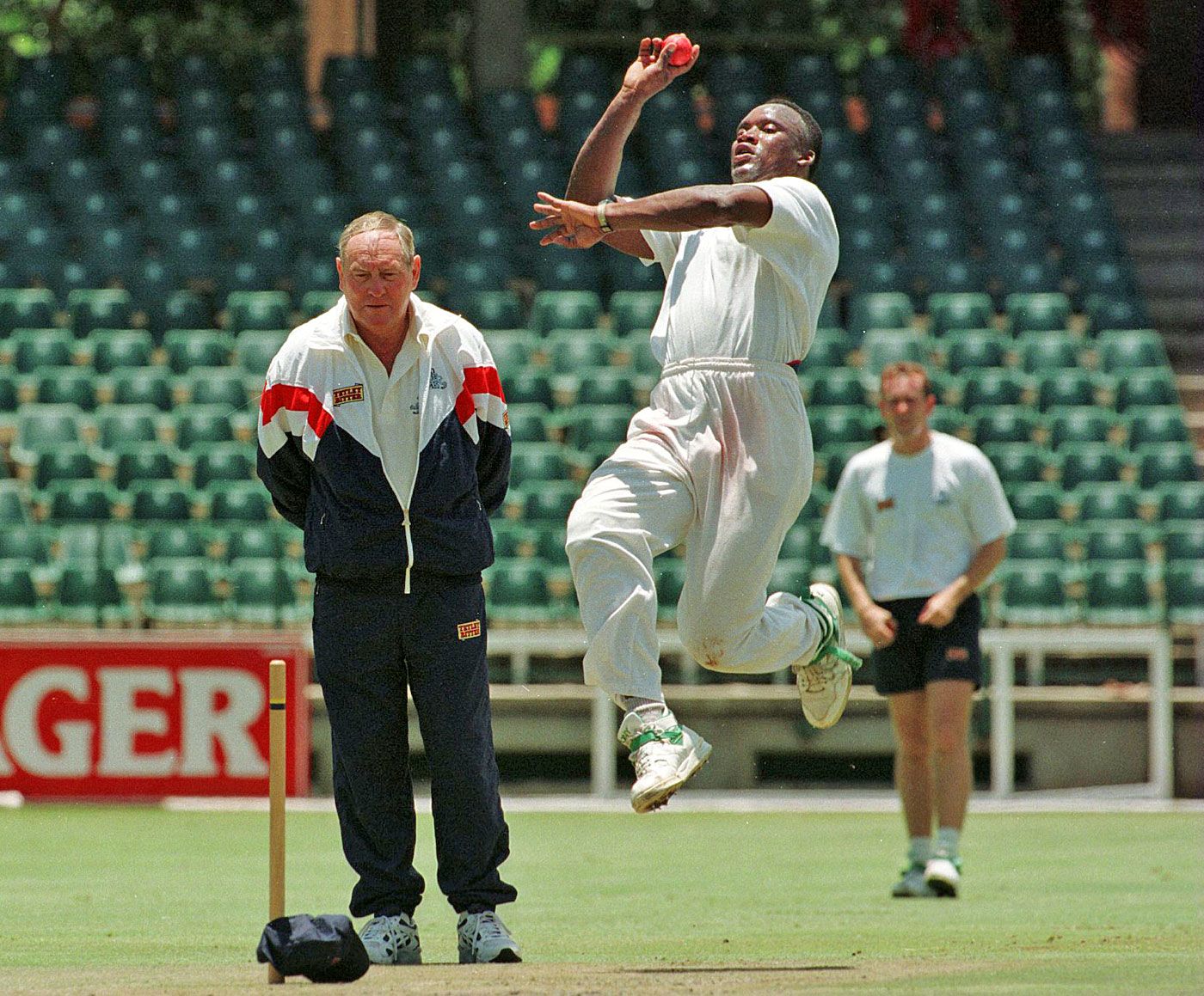 Devon Malcolm bowls as Ray Illingworth looks on