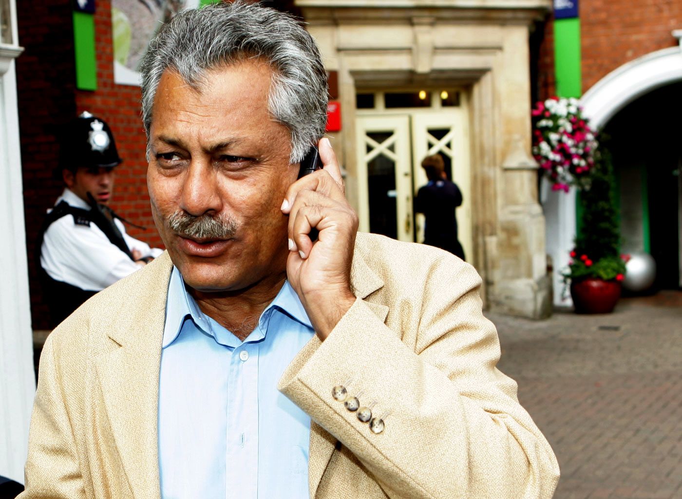 Zaheer Abbas talks on the phone as he walks towards the team bus at The Oval