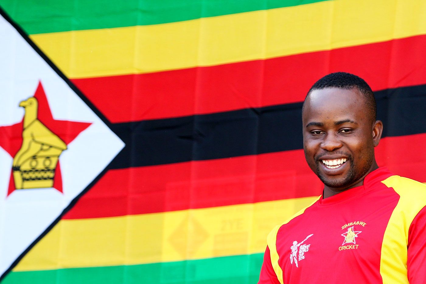 Prosper Utseya looks on with the Zimbabwe flag in the background