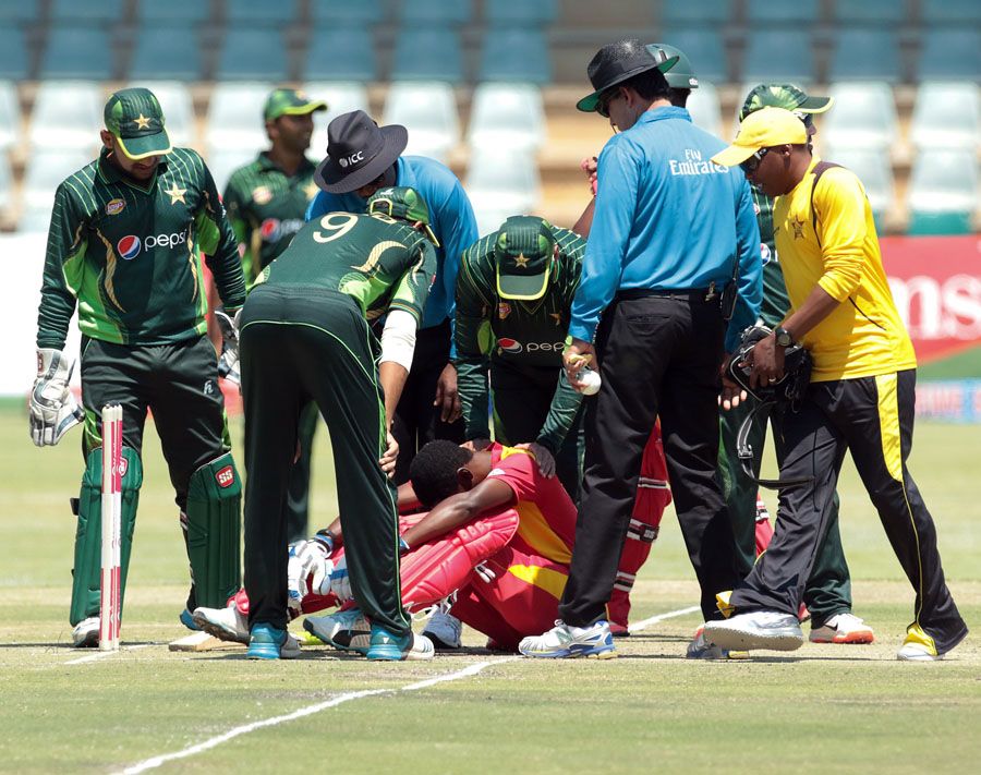 The Pakistan players check on Richmond Mutumbami after he was struck by a bouncer
