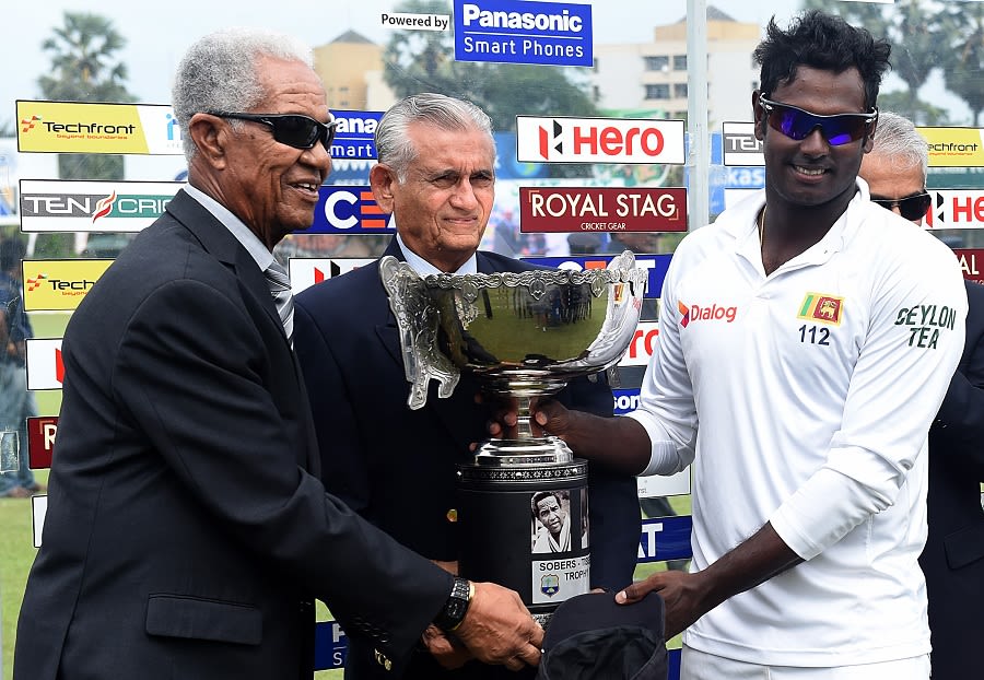 Angelo Mathews collects the trophy from Garry Sobers and Michael Tissera
