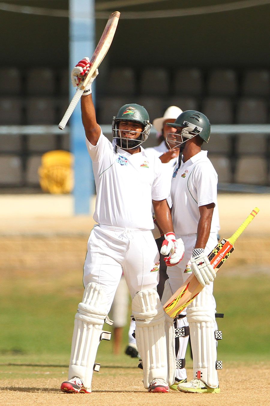 Assad Fudadin raises his bat after reaching his century