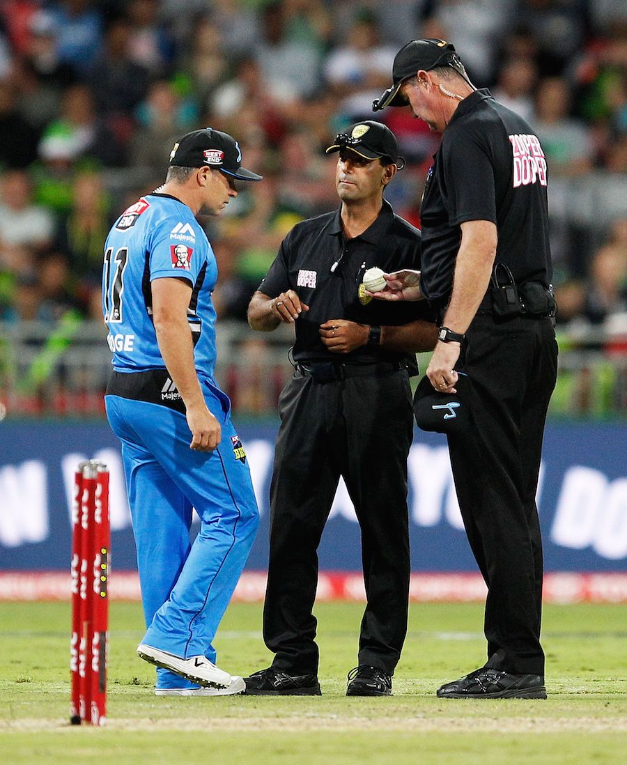 Umpires Greg Davidson and Gerard Abood inspect the ball with Brad Hodge
