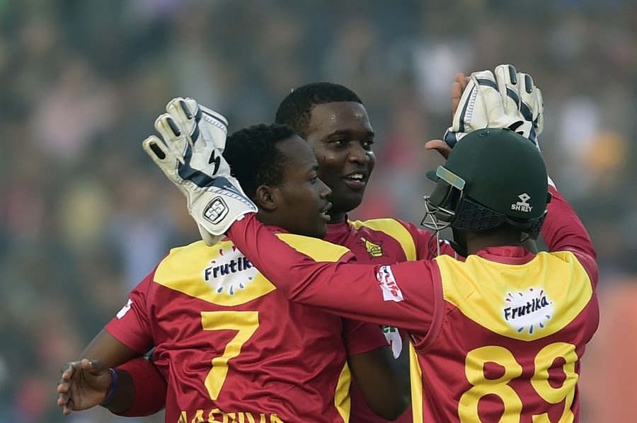 Tendai Chisoro and Neville Madziva celebrate a wicket