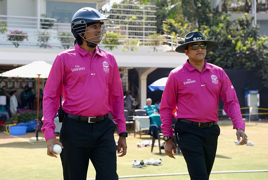 Umpire Pashchim Pathak takes the field wearing a helmet