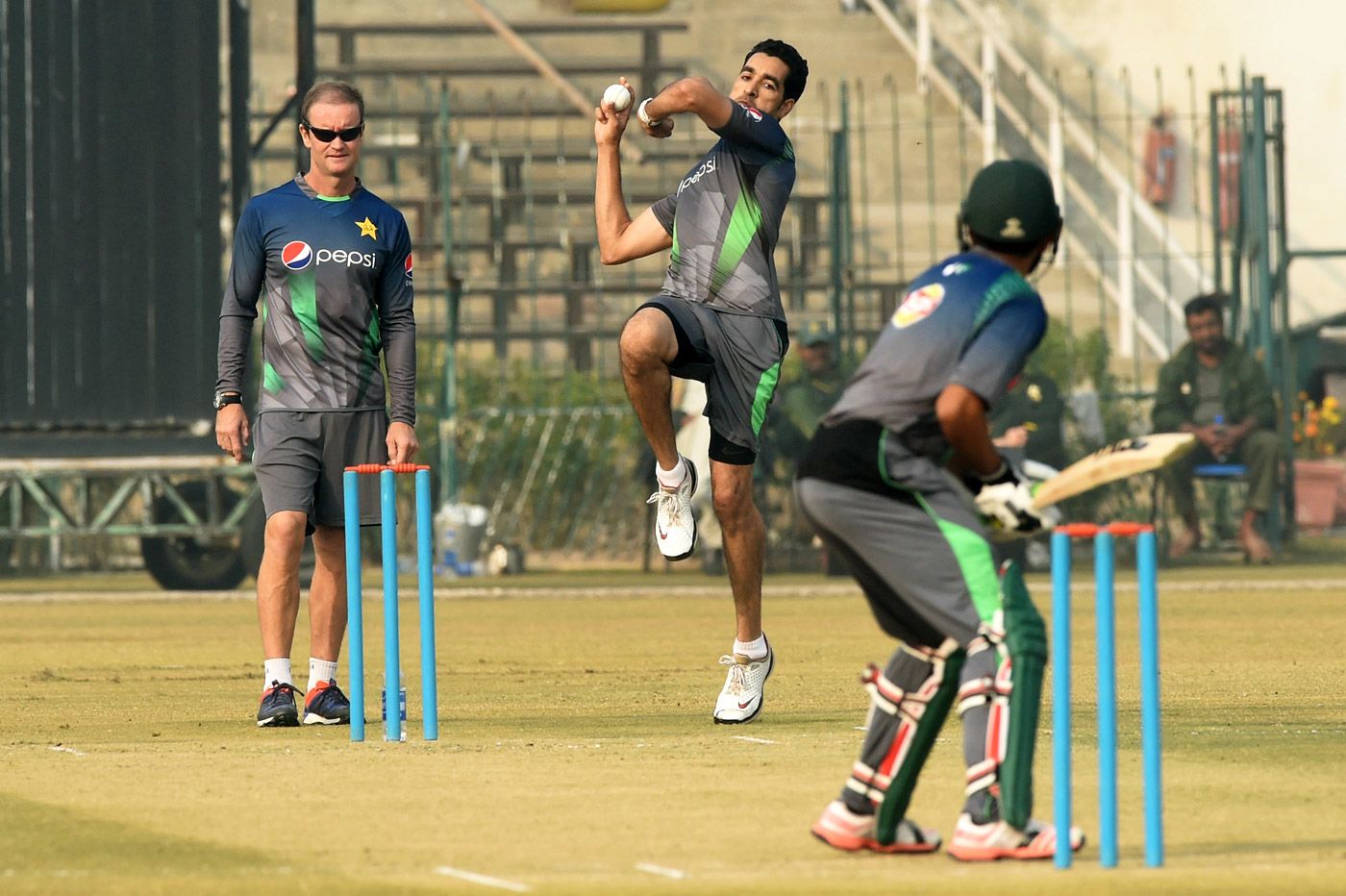 Grant Flower watches Umar Gul bowl during a practice session in Lahore