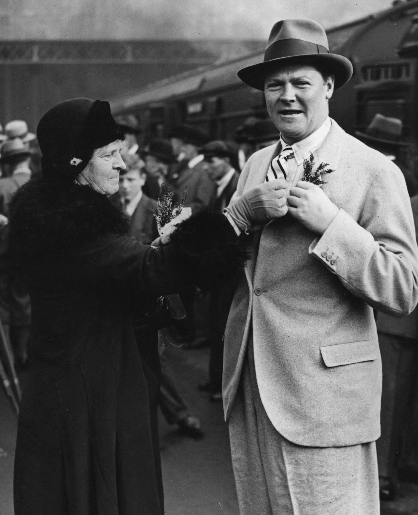 England captain Percy Chapman receives a sprig of "lucky" heather from his mother before leaving for the tour of South Africa
