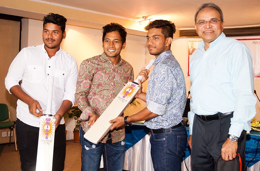 Mushfiqur Rahim hands over a batsto Under-19 cricketers Zakir Hasan and Pinak Ghosh at a promotional event