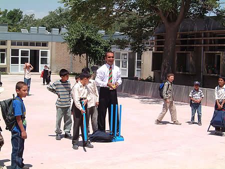 Khushal Khan High School children receiving tips from Taj Malik using Kwik cricket set donated by ECB
