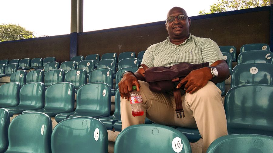 Philo Wallace sits alone in the stands at Queen's Park Oval