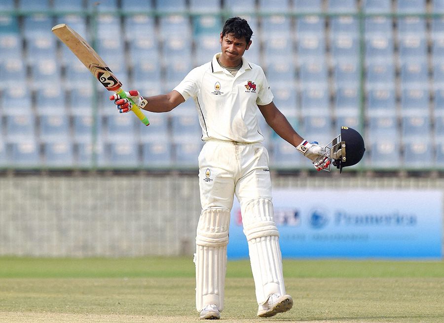 Kaustubh Pawar raises his bat after scoring a hundred