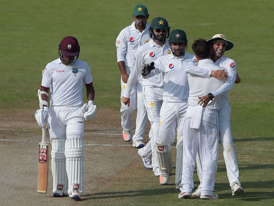 Pakistan fielders embrace Yasir Shah as Leon Johnson walks back to the dressing room