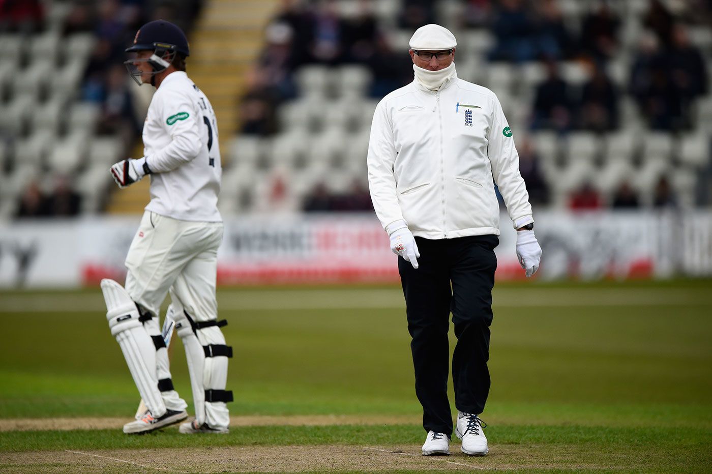 Umpire Neil Mallender feels the cold