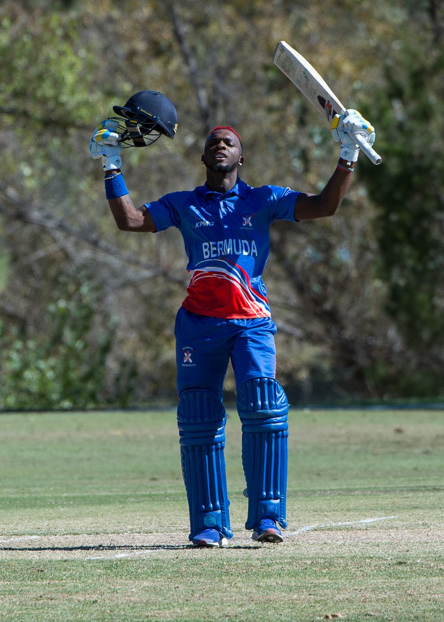 Kamau Leverock raises his bat upon reaching his century off 96 balls