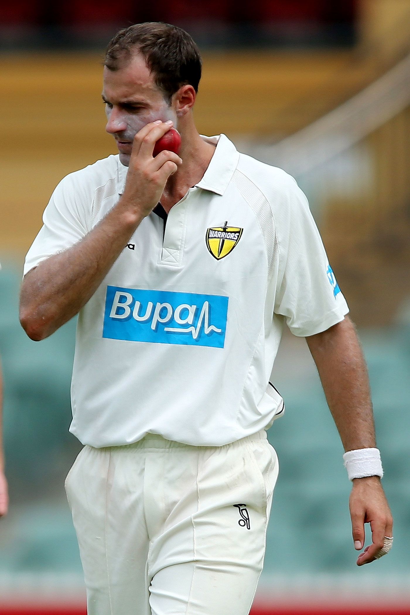 Burt Cockley appears to be rubbing the ball on his face