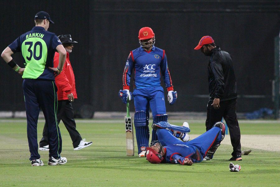 Najeeb Tarakai receives treatment after being hit by a throw