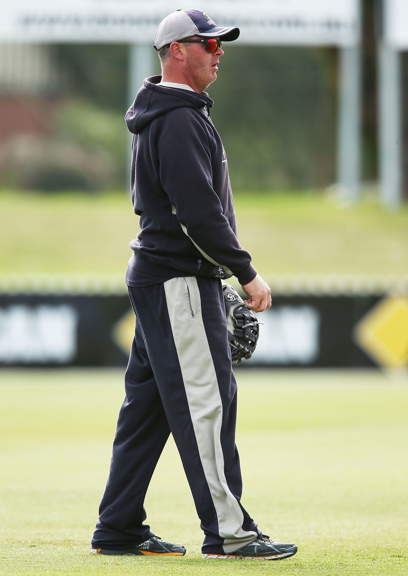 Victoria's bowling coach Mick Lewis helps the players warm up