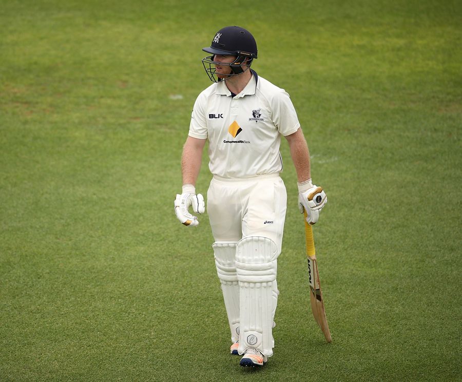 Travis Dean walks back after being bowled for a duck