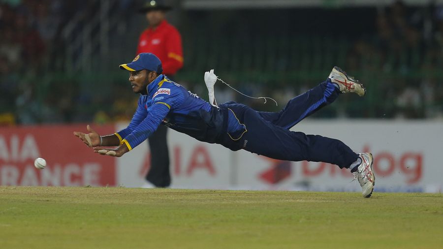 Dilshan Munaweera has a shy at the stumps while being air borne