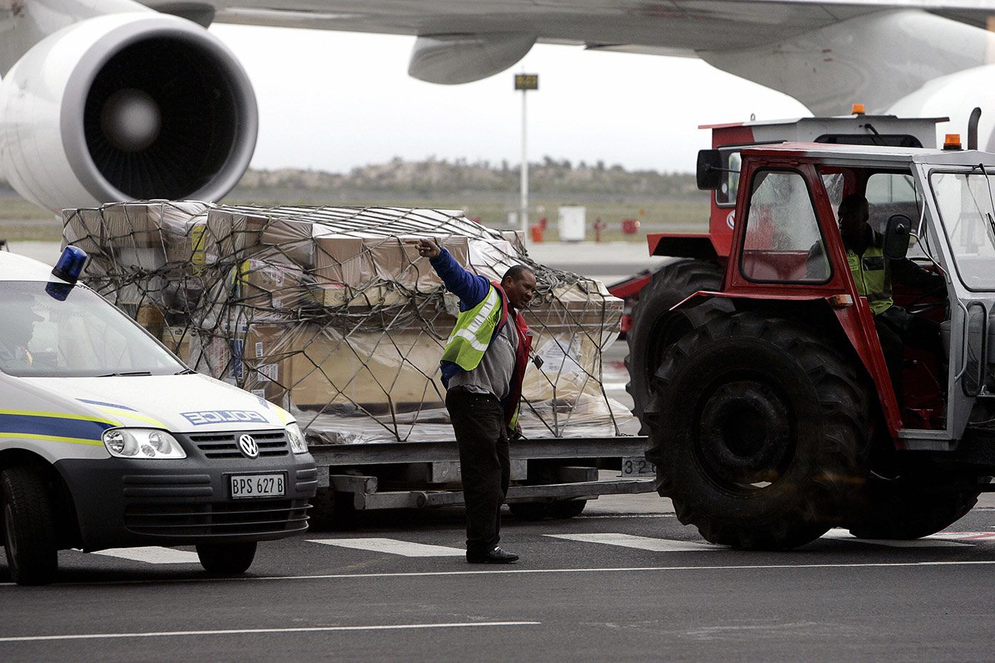A wooden box containing the body of Bob Woolmer is offloaded from an airplane