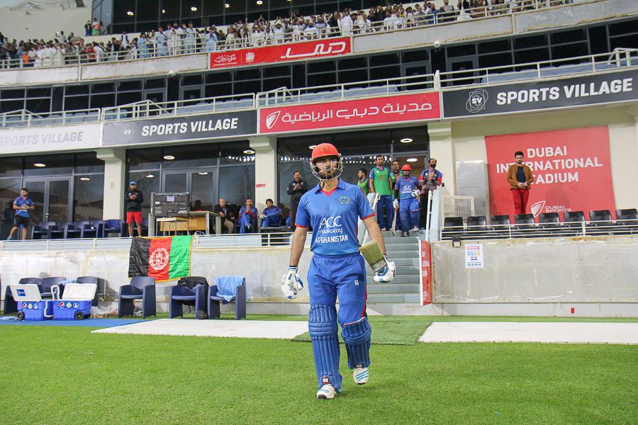 Nawroz Mangal is clapped onto the field by team-mates and fans as he walks out for his final innings