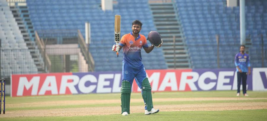 Junaid Siddique raises his bat after notching up his century