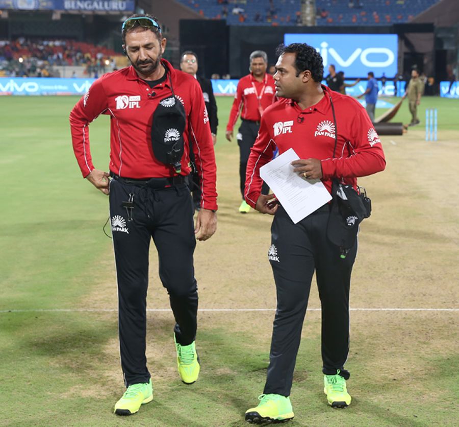 Umpires Nitin Menon and Anil Chaudhary have a chat after inspecting the pitch