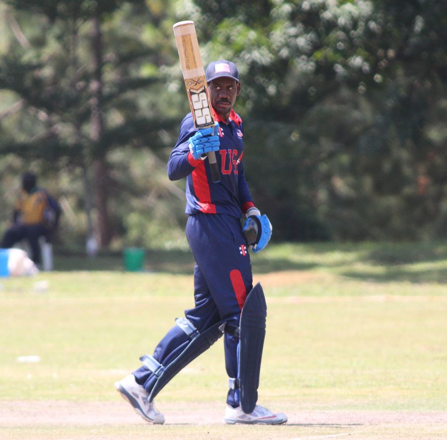 Elmore Hutchinson raises his bat after reaching a half-century