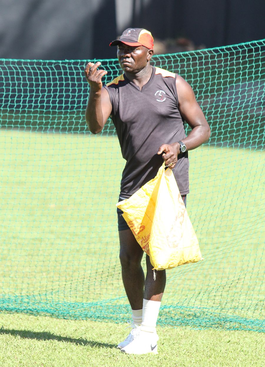 Uganda coach Steve Tikolo helps a batsman practice the sweep with some underhand throws