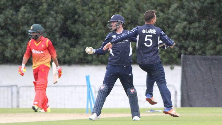 Con de Lange and Matthew Cross celebrate Sikandar Raza runout as rain comes down