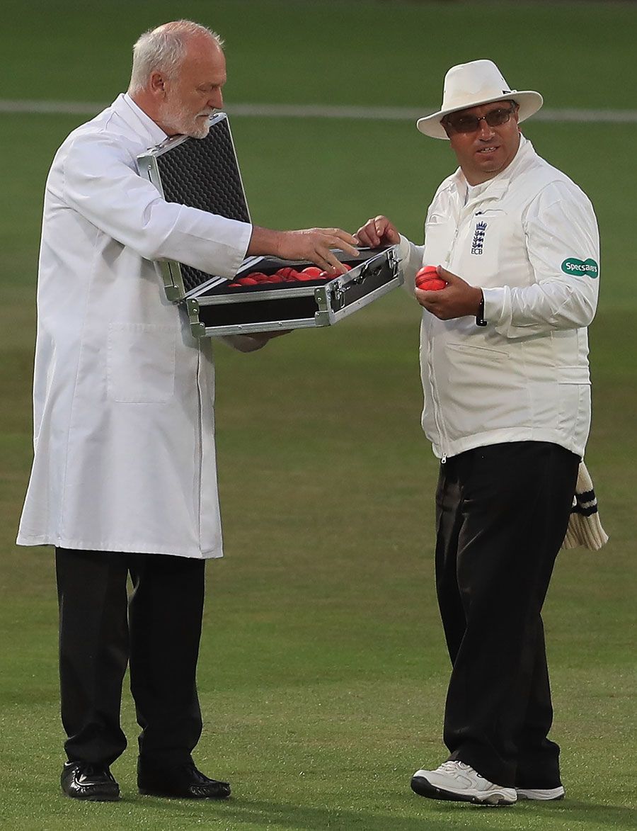 Umpire Neil Bainton selects a new pink ball from the box of replacements