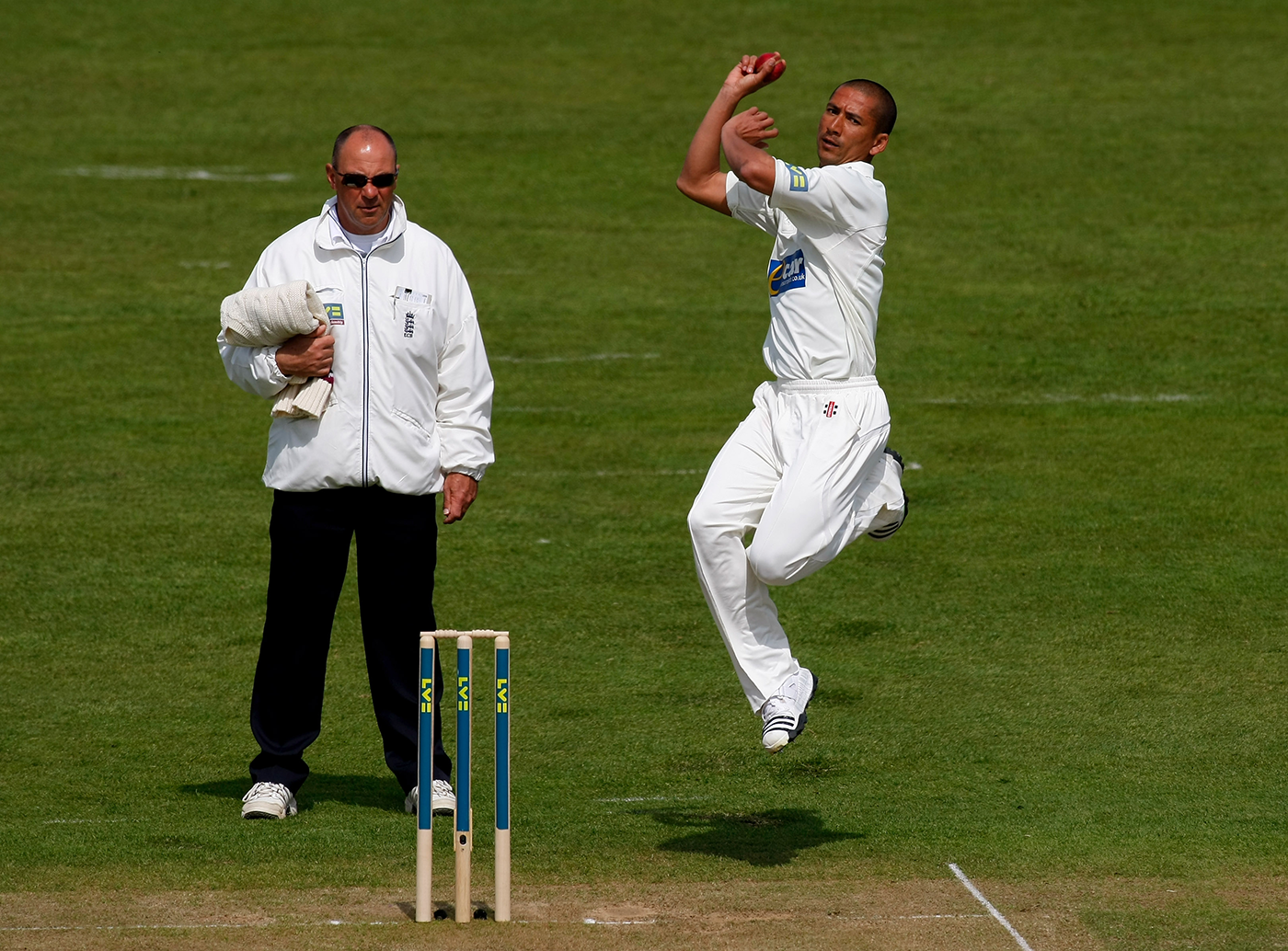 Umpire Tim Robinson watches Alfonso Thomas bowl