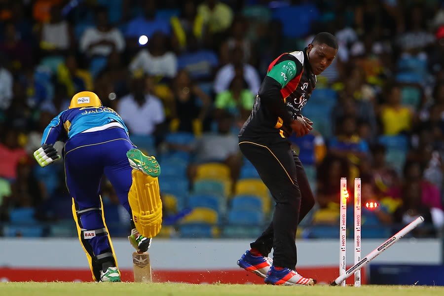 Sheldon Cottrell breaks the stumps to run out Damien Jacobs