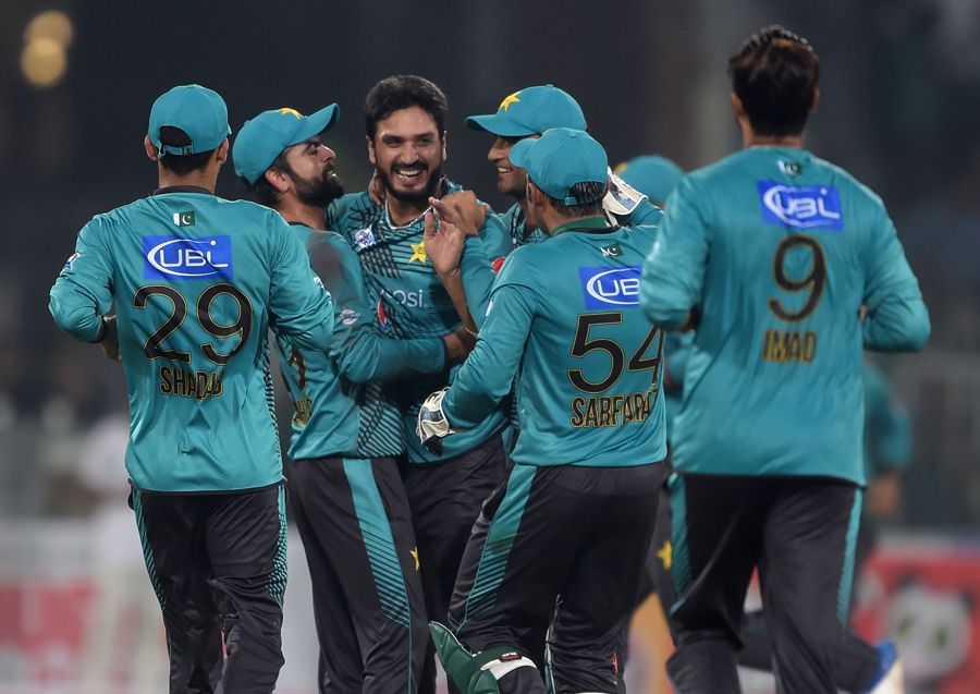 Rumman Raees is mobbed by his team-mates after he sent both the openers back in the same over